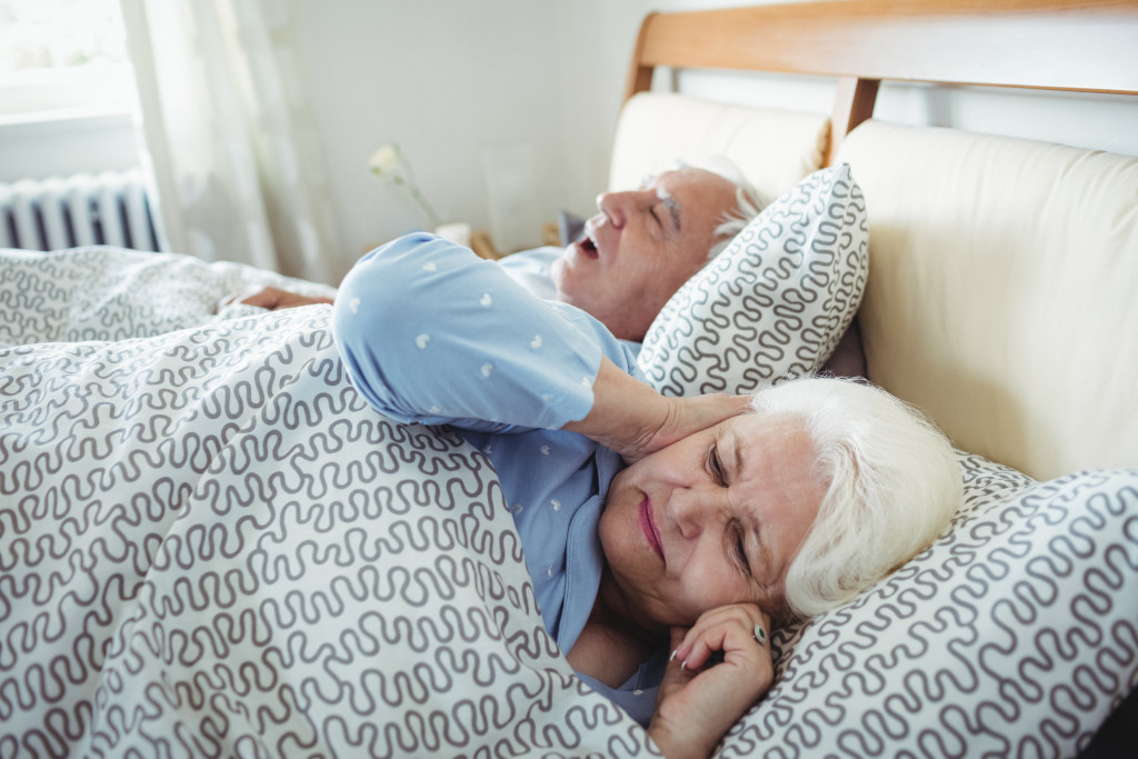 sleeping senior couple with male snoring