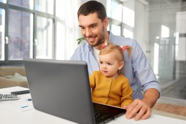 father and daughter using family's laptop