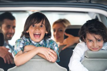 kids at the back of the car with parents
