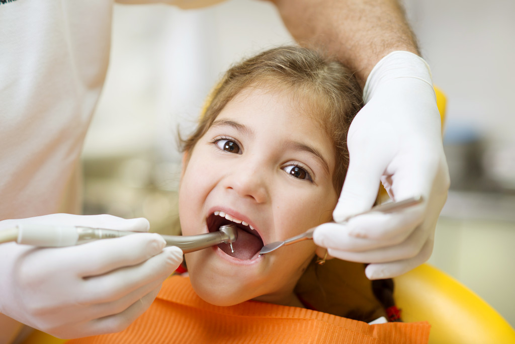 A child getting her teeth checked at the dentist clinic