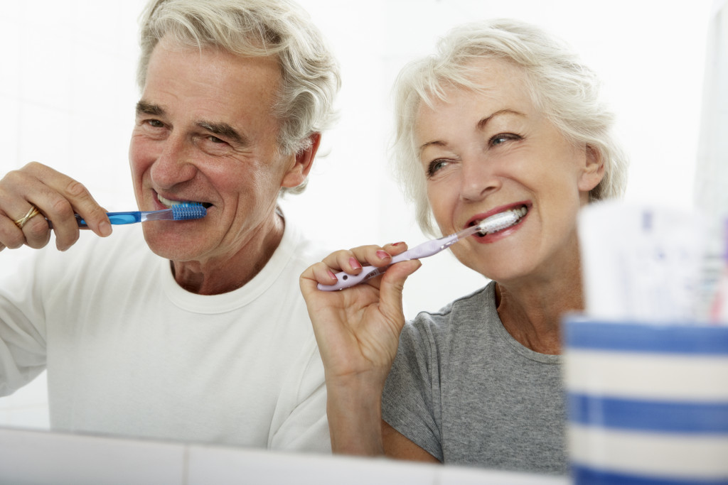 Two seniors brushing their teeth