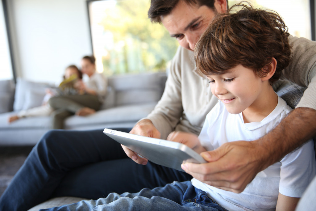a father and son using a digital tablet device