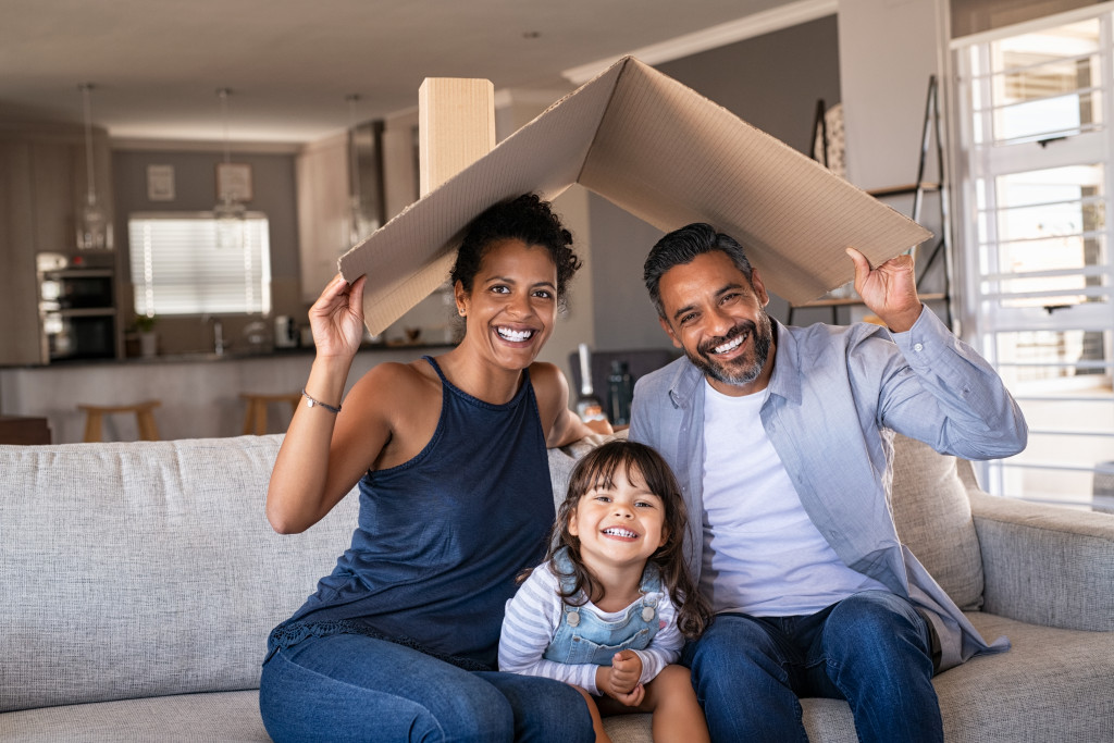 smiling family holding cardboard roof concept of happy family