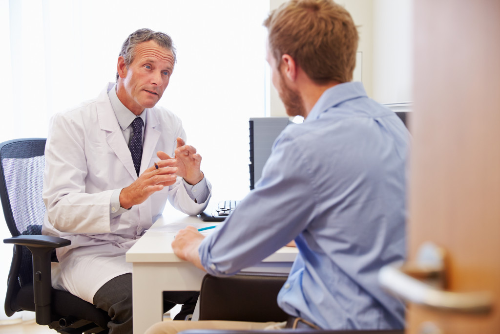 male patient talking to male doctor explaining things in his office