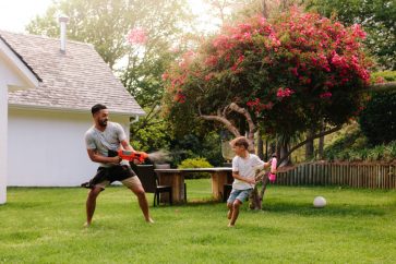 a father playing with young daughter in the backyard