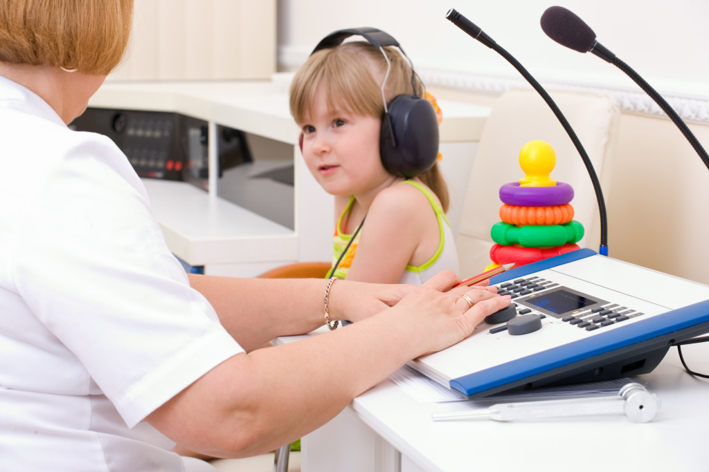 audiologist testing girl's ear